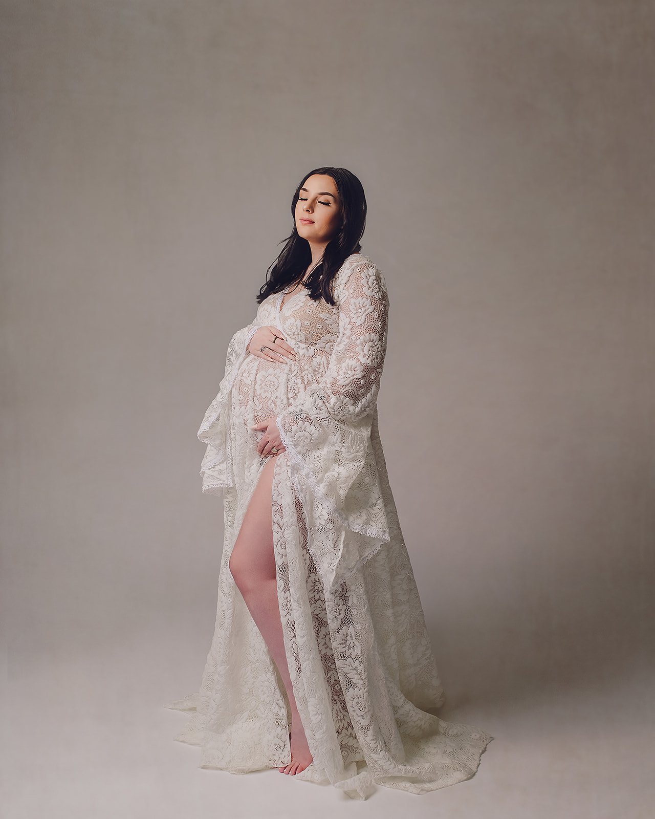 pregnant mom in white gown holding her bump Meridian Wellness Center