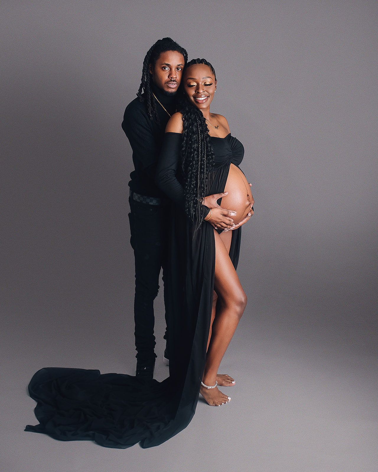 dad and mom to be in black maternity gown medford-wellness center