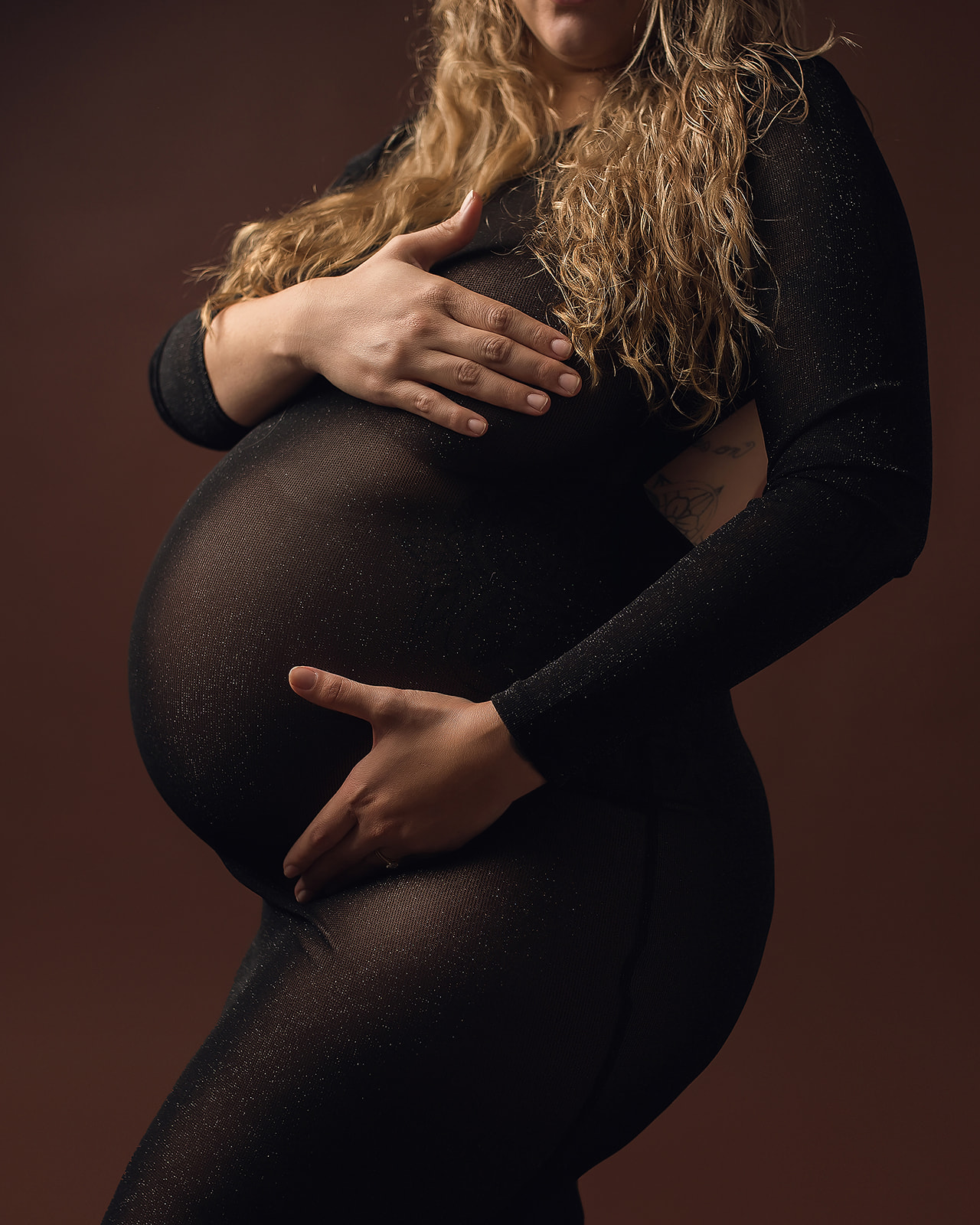 mom to be in dark maternity gown holding her bump Rogue Valley Doulas
