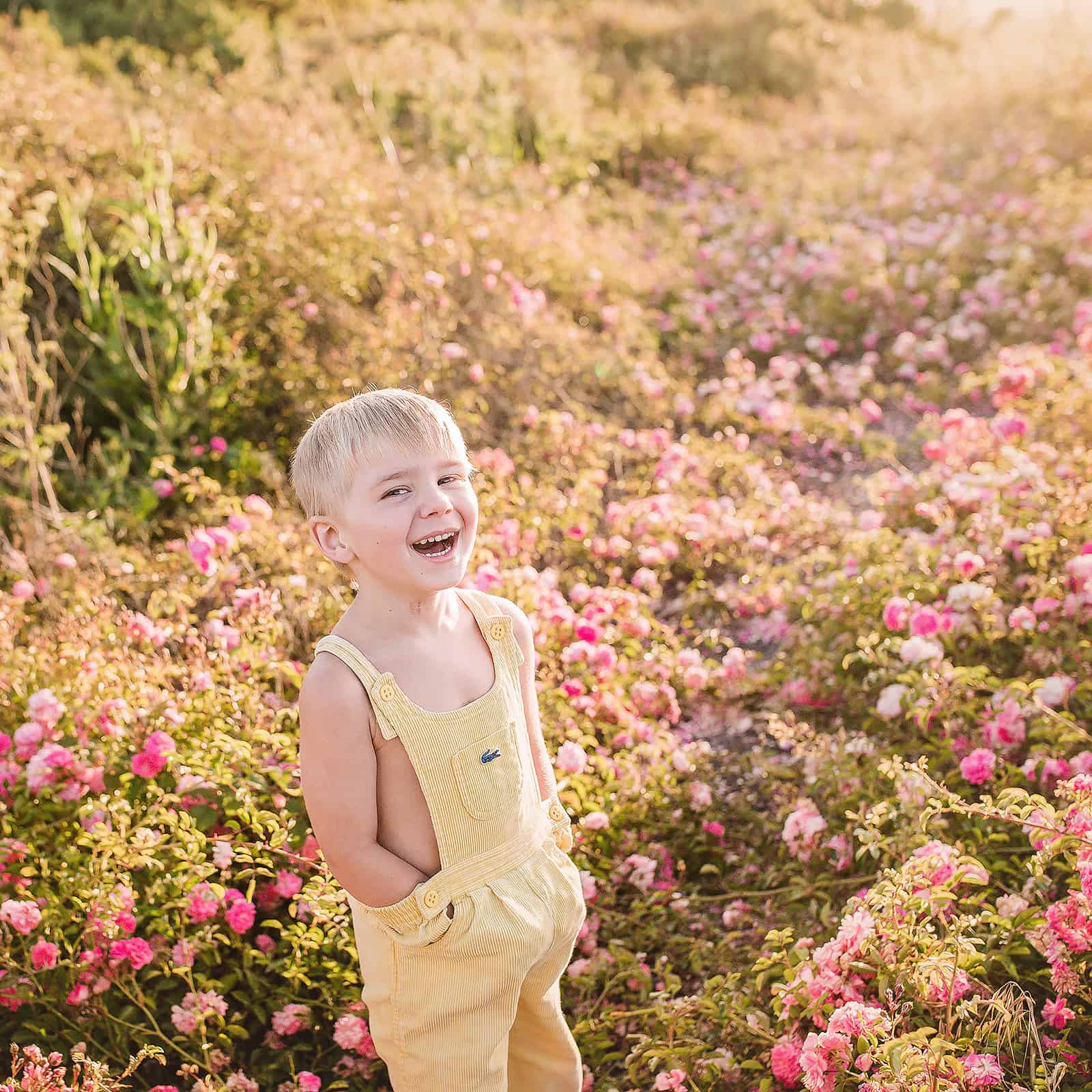 Little boy in yellow Lacoste overalls laughing in a flower field Things to do in Medford OR