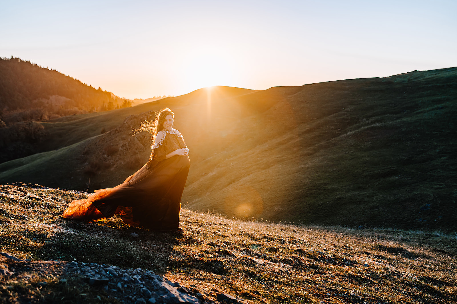 mom to be at sunset in a maroon maternity gown on a mountain Siskiyou Vital Medicine